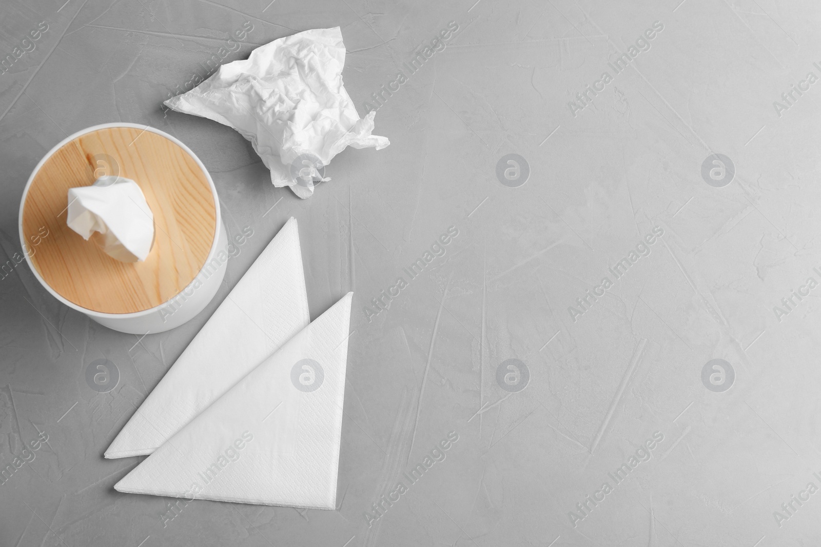 Photo of Wooden box with tissues and napkins on light table, flat lay. Space for text