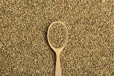 Wooden spoon and hemp seeds, top view