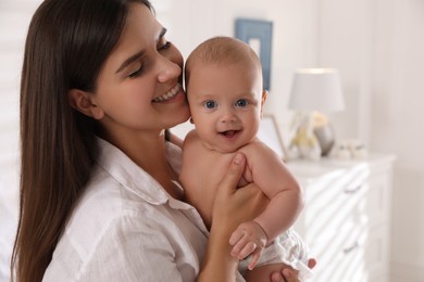 Happy young mother with her cute baby at home