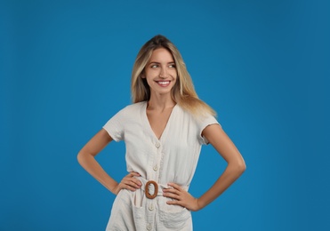 Young woman wearing stylish dress on blue background