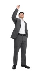 Businessman in suit with marker writing on white background, low angle view