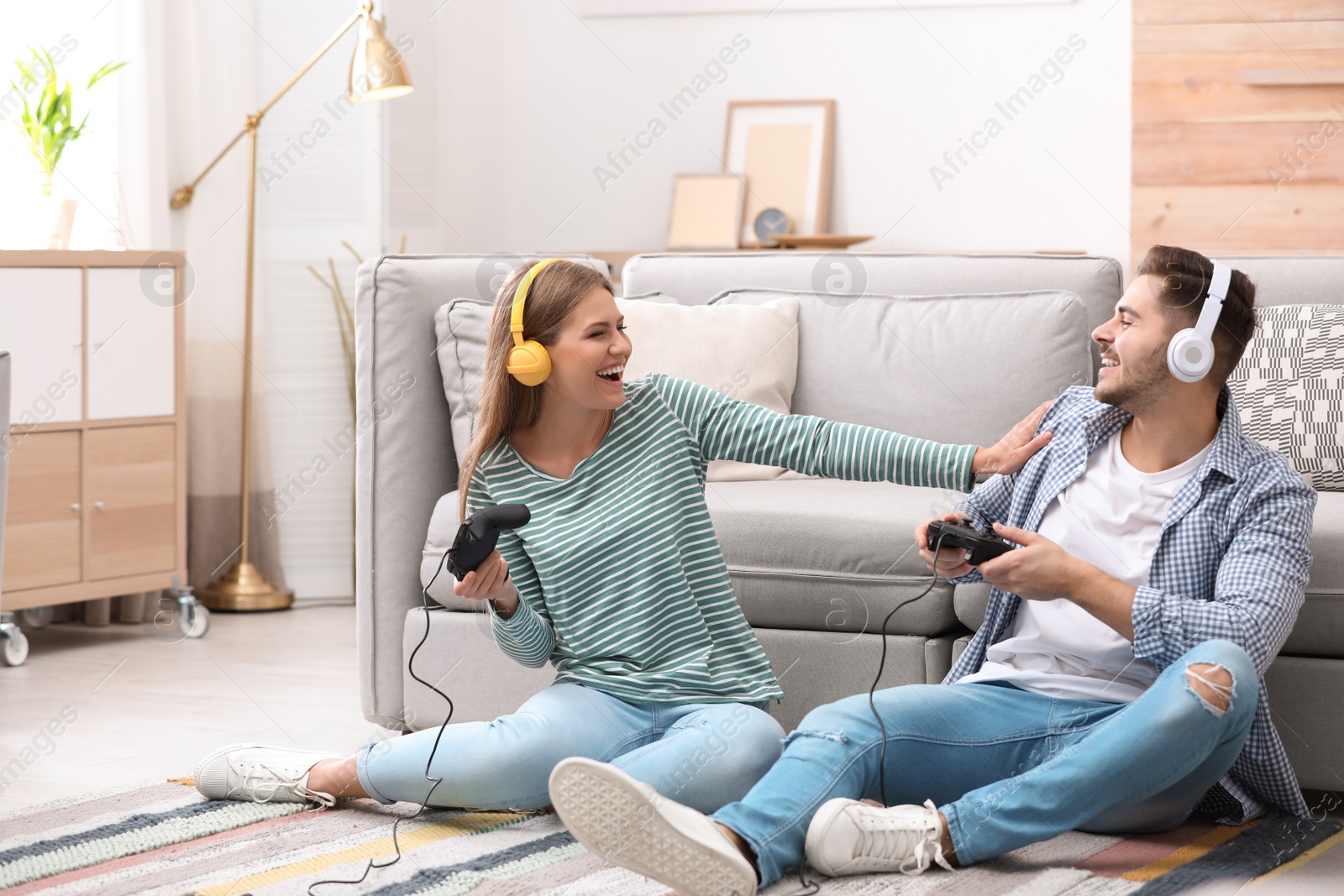 Photo of Emotional young couple playing video games at home