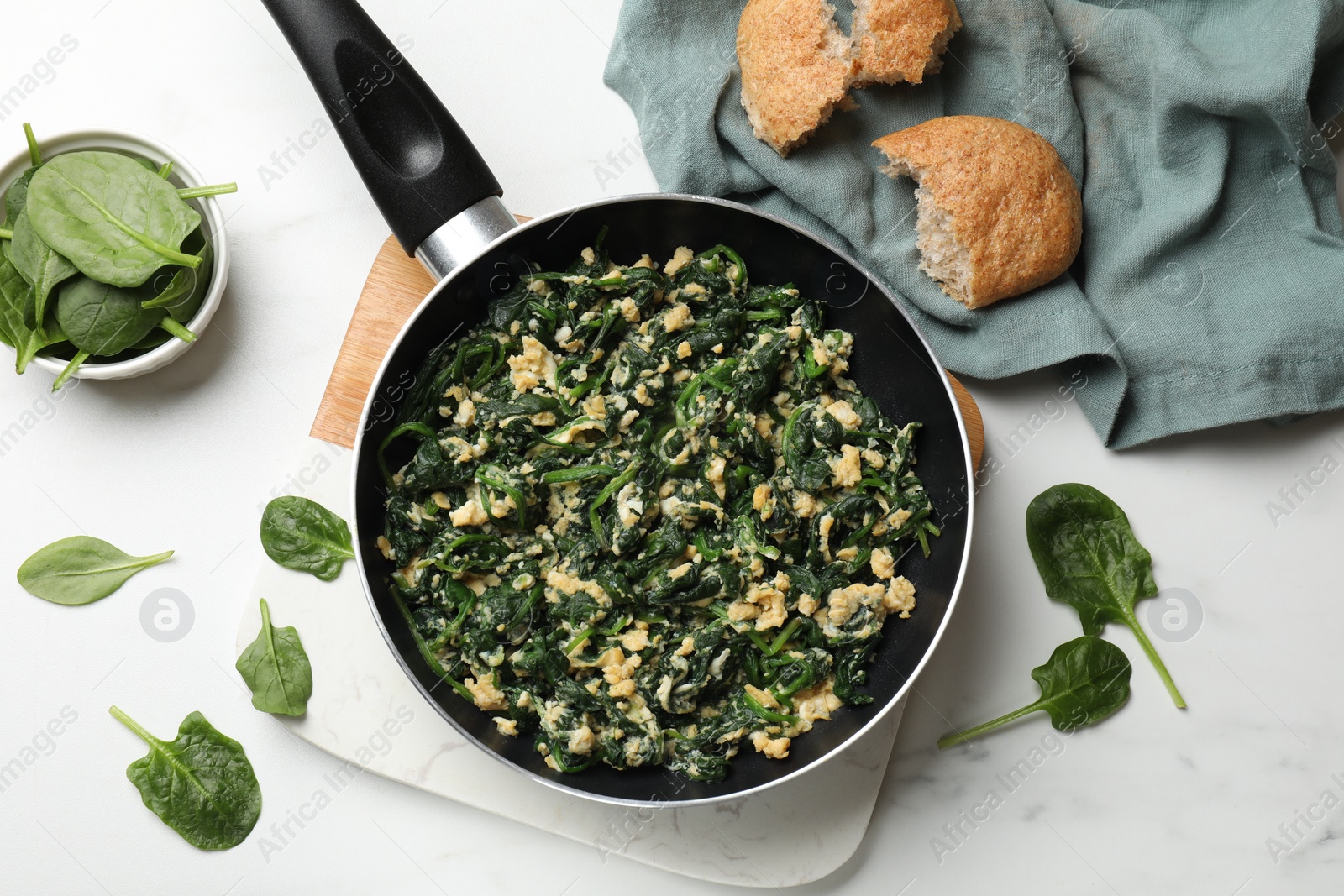 Photo of Tasty spinach dip with eggs in dish served on white table, flat lay