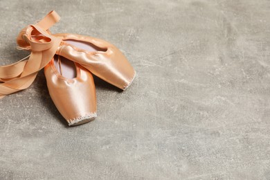 Photo of Ballet shoes. Elegant pointes on grey textured background, space for text
