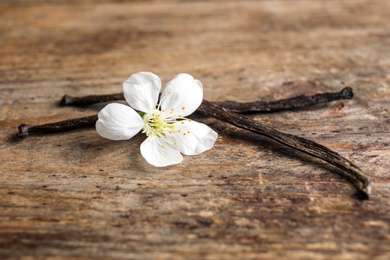 Aromatic vanilla sticks and flower on wooden background