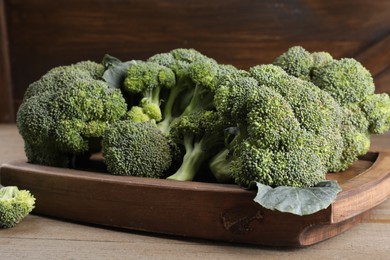 Tray with fresh raw broccoli on wooden table, closeup