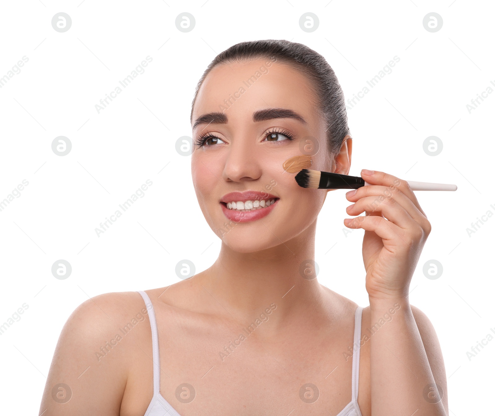 Photo of Woman applying foundation on face with brush against white background