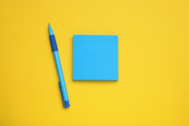 Photo of Paper notes and pen on yellow background, flat lay