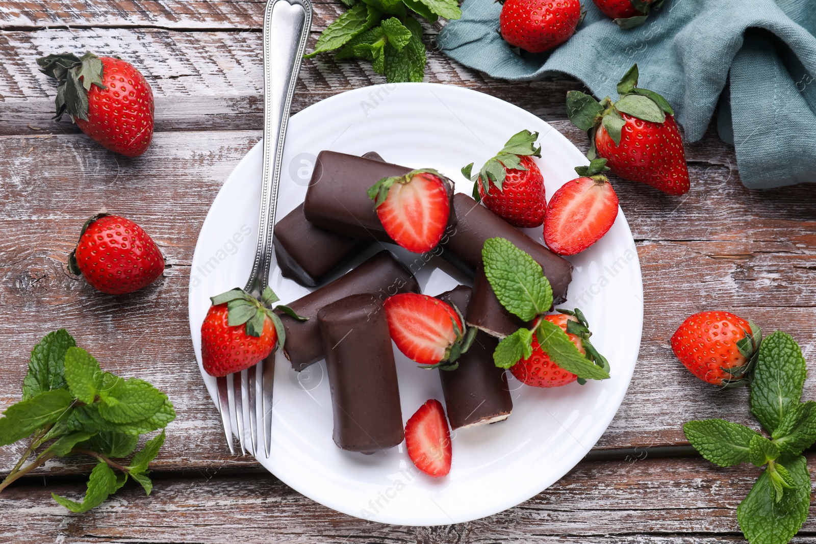 Photo of Delicious glazed curd snacks with fresh strawberries and mint on wooden table, flat lay