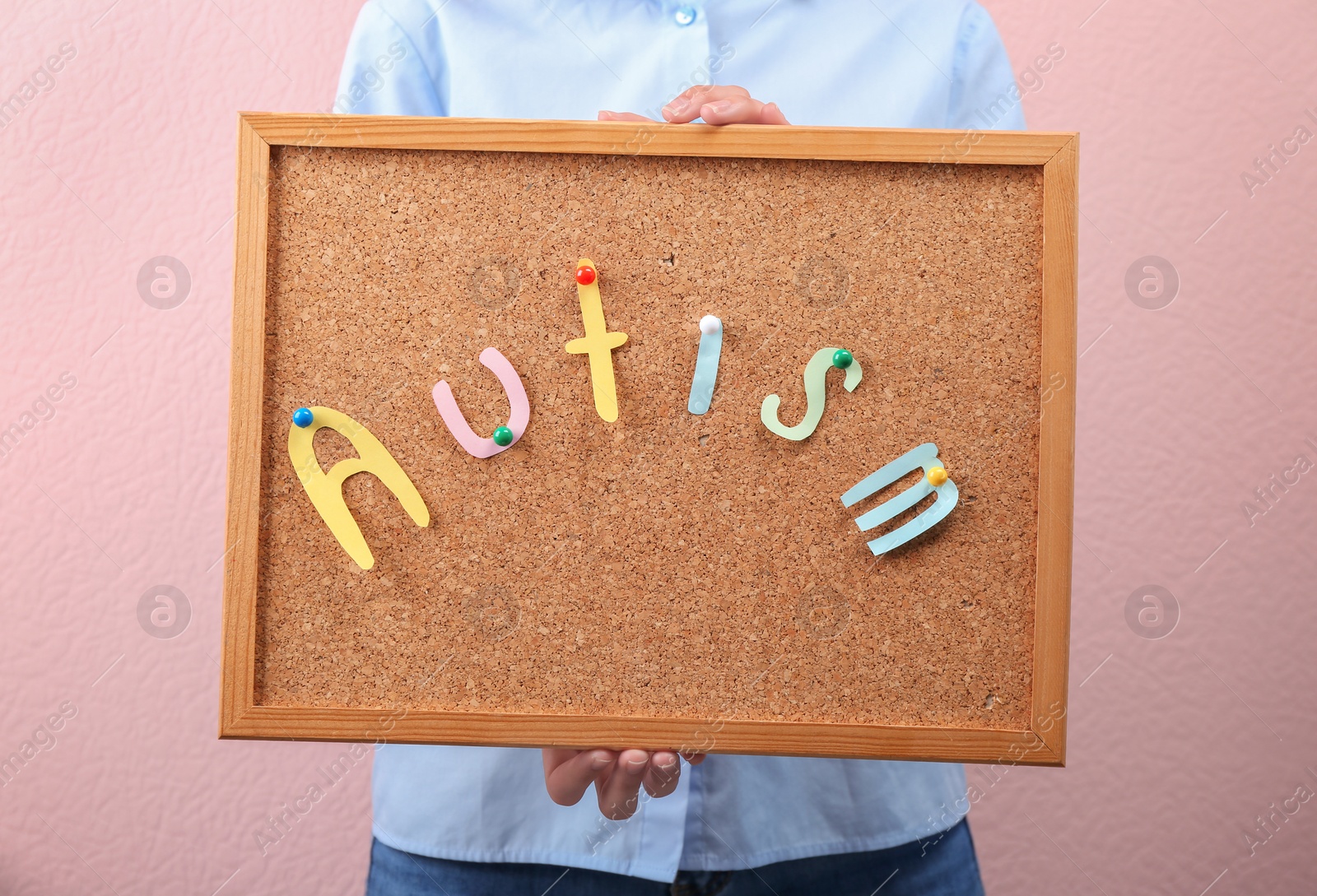 Photo of Woman holding board with word "Autism" on color background