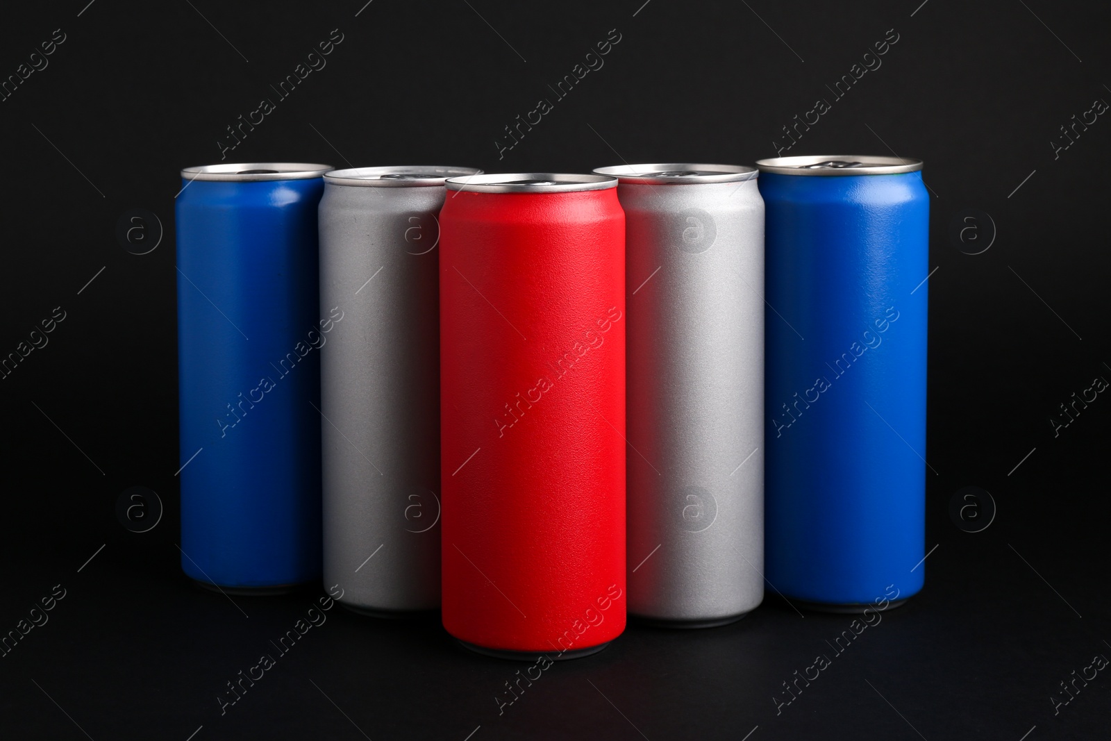 Photo of Energy drinks in colorful cans on black background