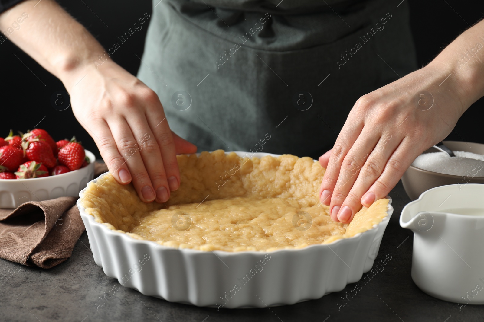 Photo of Shortcrust pastry. Woman making pie at grey table, closeup