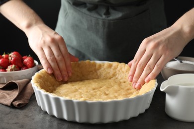 Shortcrust pastry. Woman making pie at grey table, closeup