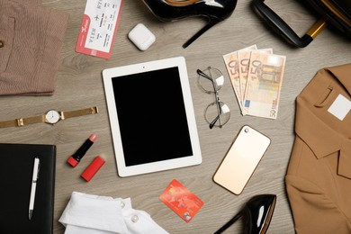 Photo of Flat lay composition with clothes, shoes and accessories on wooden background. Packing for business trip