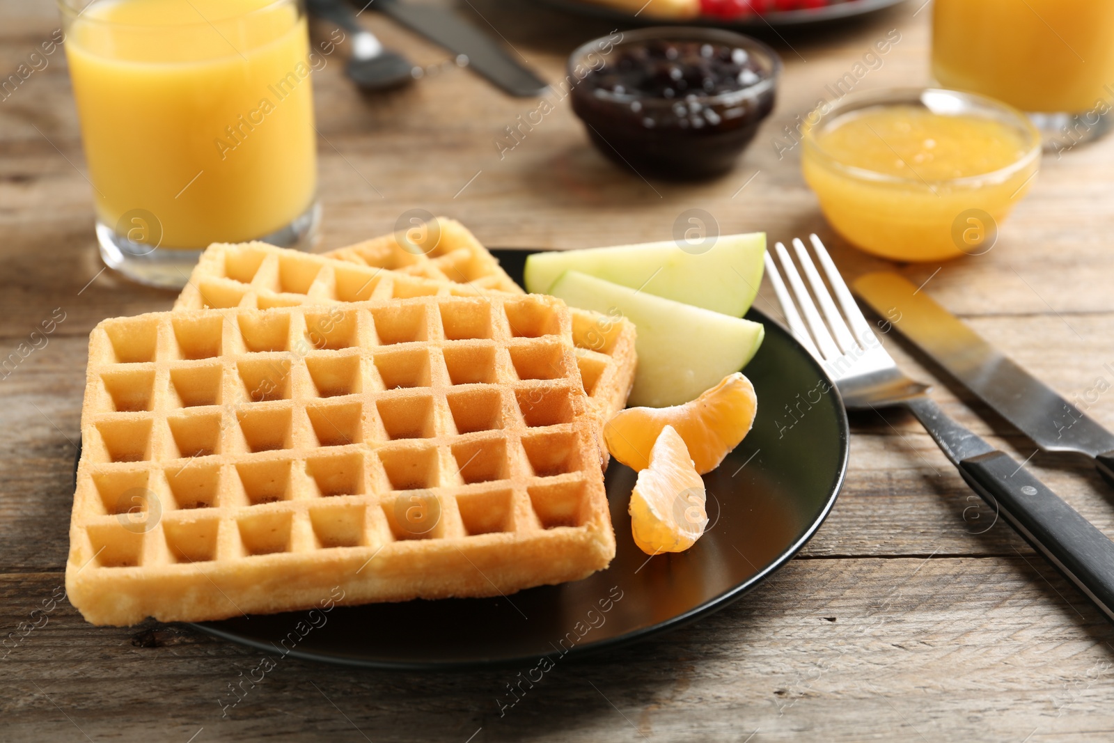 Photo of Waffles with fruits served on wooden table. Delicious breakfast