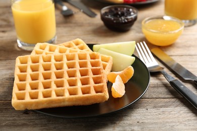 Waffles with fruits served on wooden table. Delicious breakfast