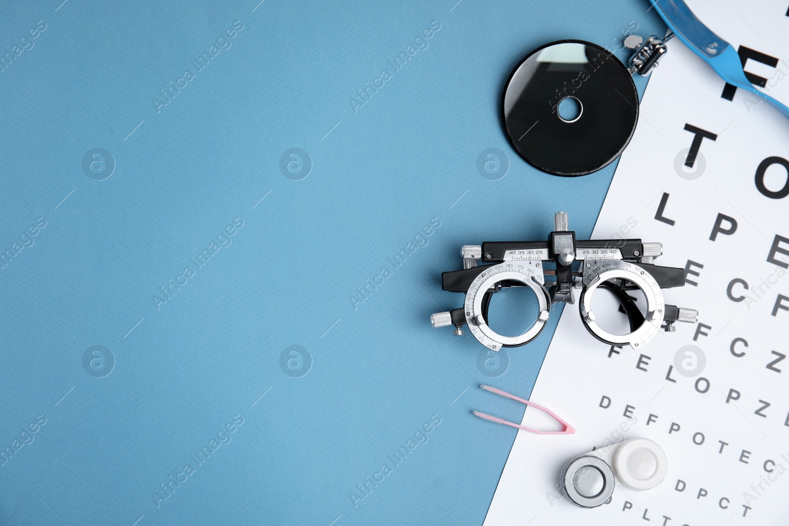 Photo of Different ophthalmologist tools on light blue background, flat lay. Space for text