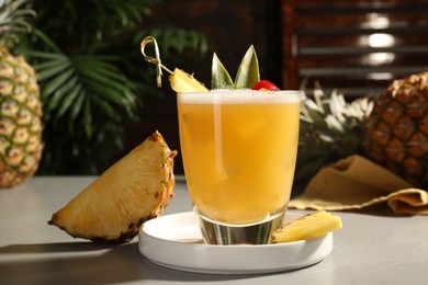 Tasty pineapple cocktail and fresh fruit on light grey table