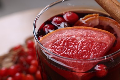 Photo of Aromatic mulled wine in glass on table, closeup