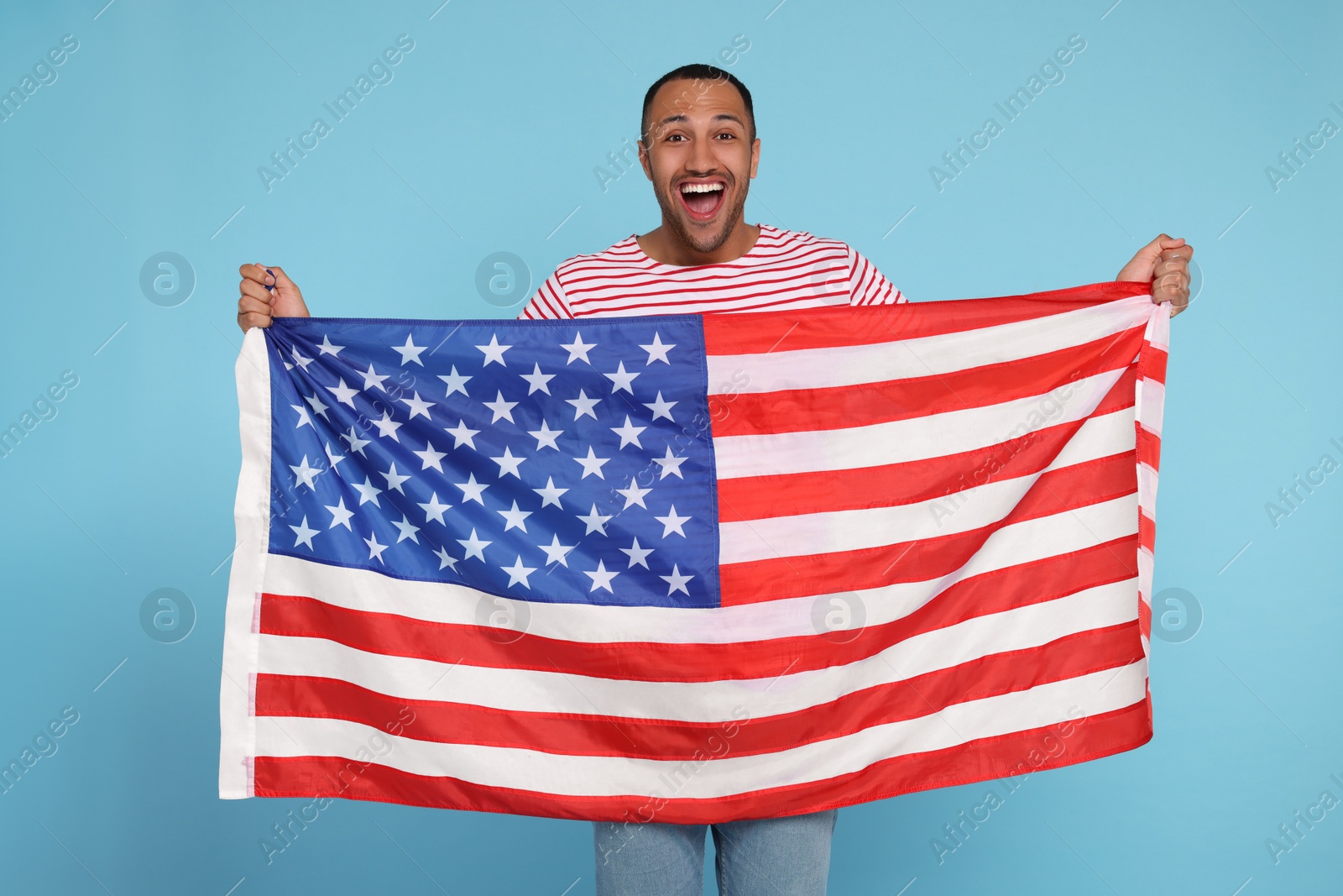 Photo of 4th of July - Independence Day of USA. Happy man with American flag on light blue background