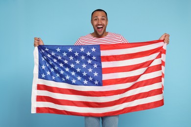 4th of July - Independence Day of USA. Happy man with American flag on light blue background