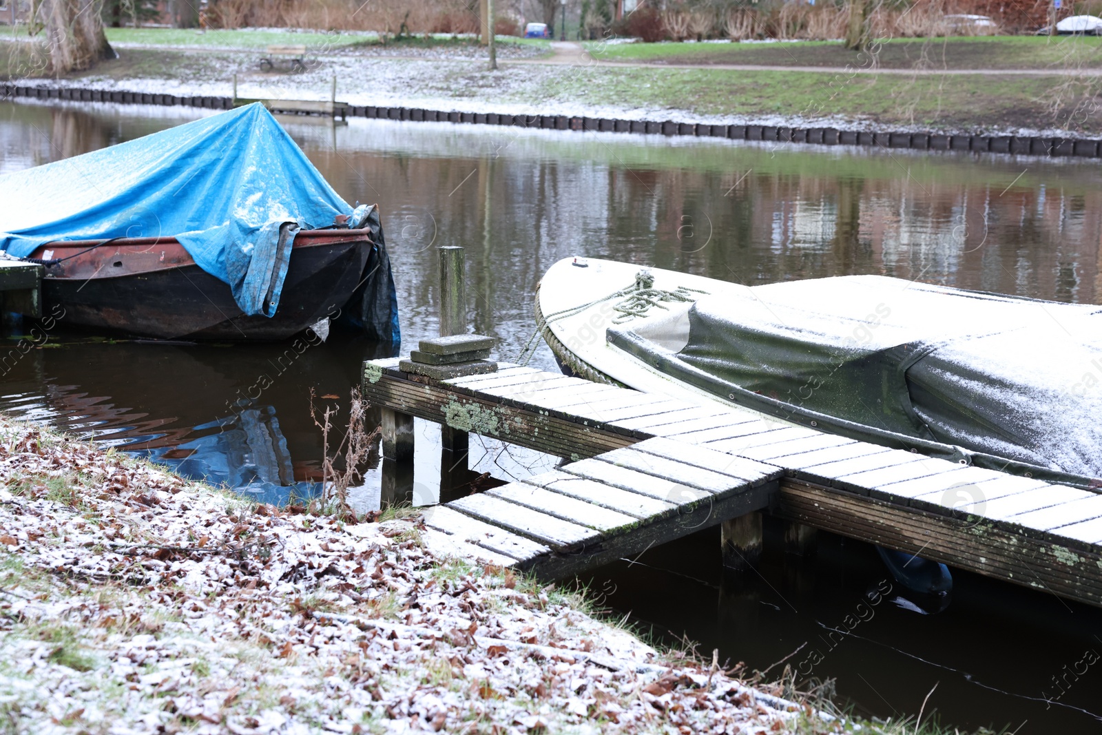 Photo of Water canal with moored boats on winter day