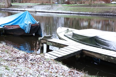 Water canal with moored boats on winter day