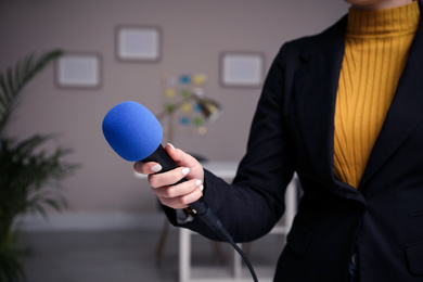 Image of Professional journalist with modern microphone in room, closeup