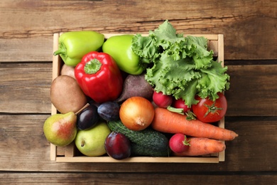 Photo of Crate full of different vegetables and fruits on wooden table, top view. Harvesting time