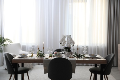 Photo of Beautiful Easter table setting with orchid flowers indoors