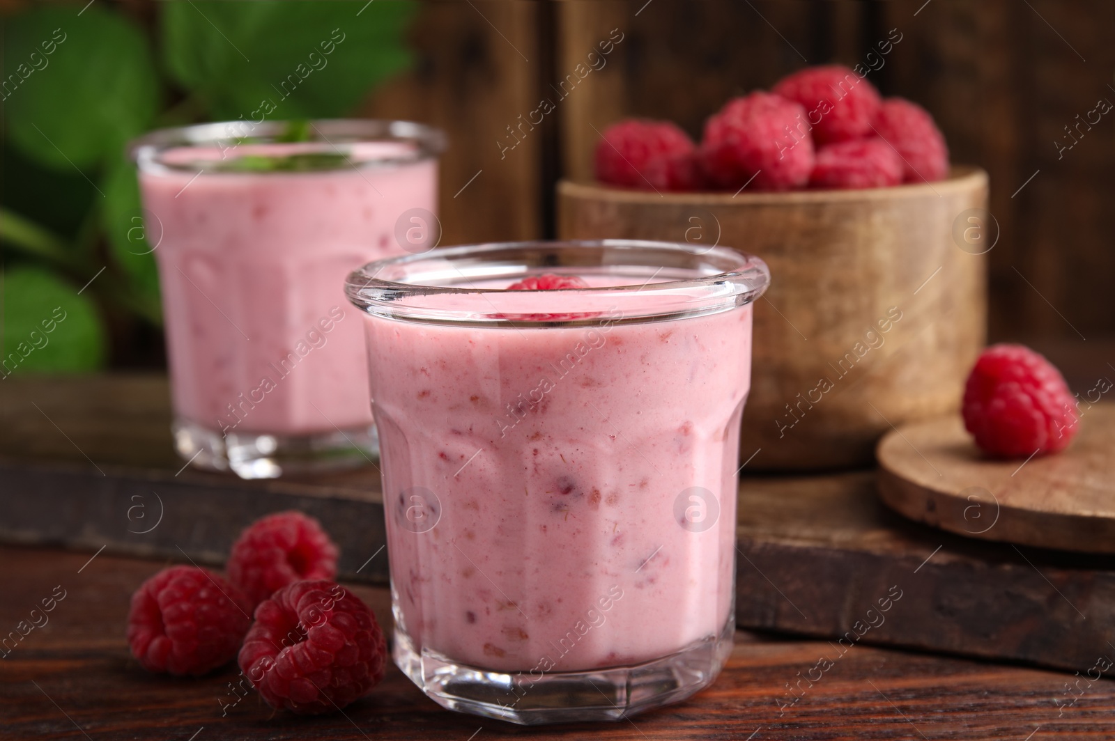 Photo of Tasty fresh raspberry smoothie on wooden table