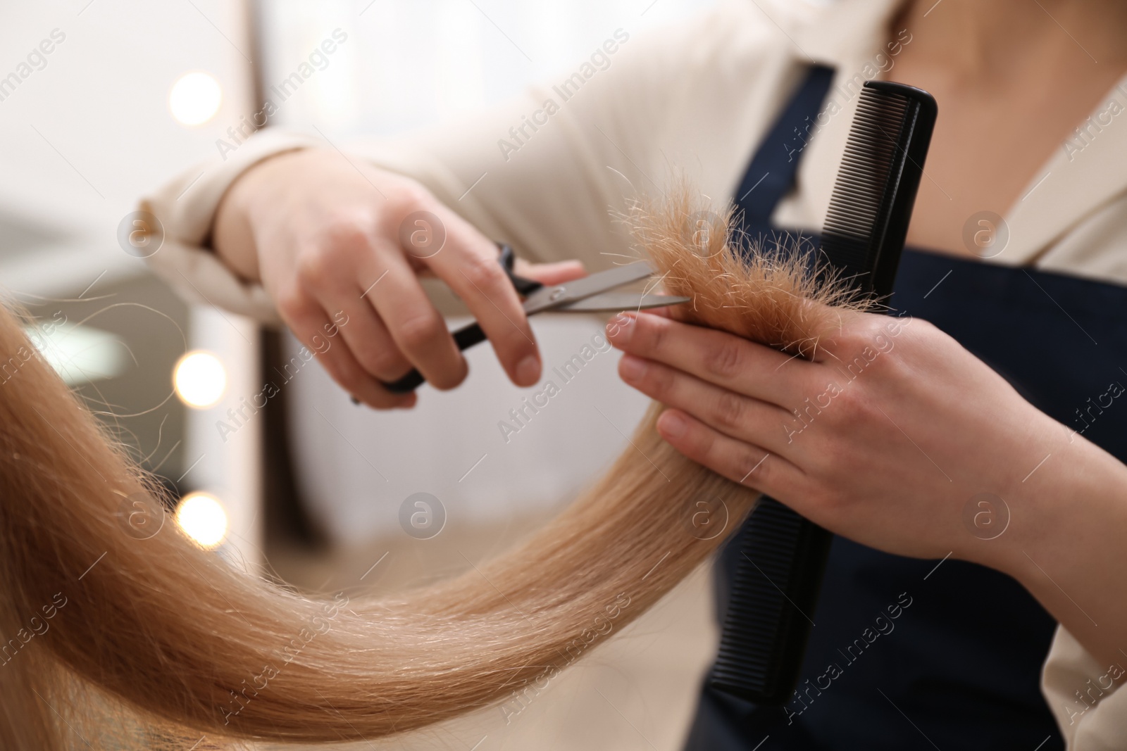 Photo of Stylist cutting hair of client in professional salon, closeup