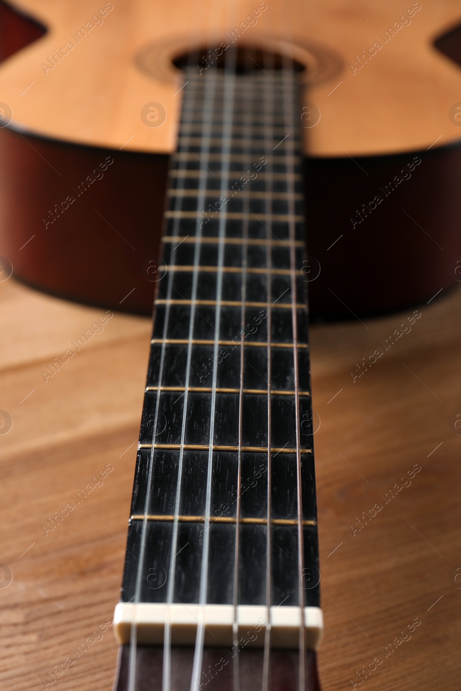 Photo of Beautiful classical guitar on wooden background, neck with strings in focus