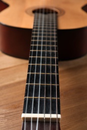Photo of Beautiful classical guitar on wooden background, neck with strings in focus