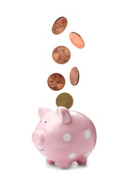 Image of Different coins falling into cute piggy bank on white background