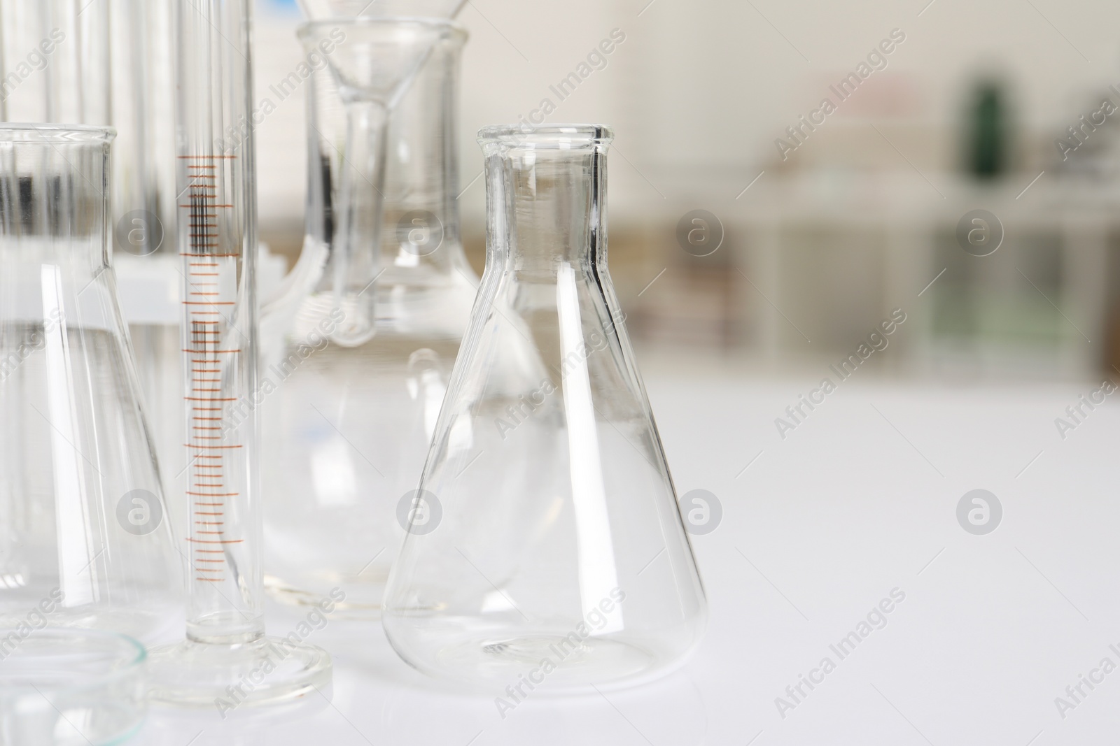 Photo of Laboratory analysis. Different glassware on white table indoors, closeup. Space for text