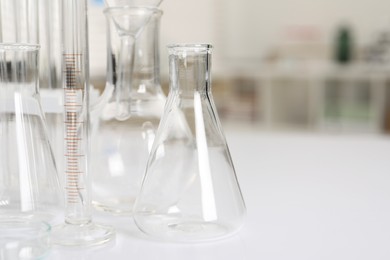 Photo of Laboratory analysis. Different glassware on white table indoors, closeup. Space for text