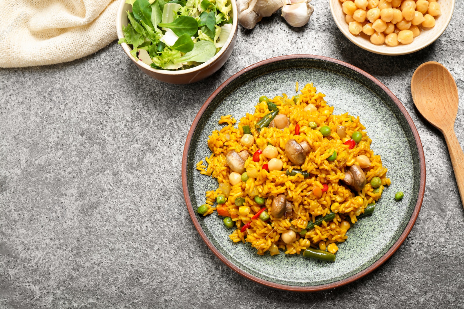 Photo of Delicious rice pilaf with vegetables on grey table, flat lay. Space for text