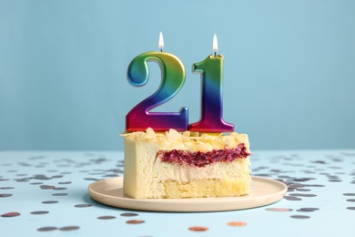 Photo of Coming of age party - 21st birthday. Delicious cake with number shaped candles on light blue background