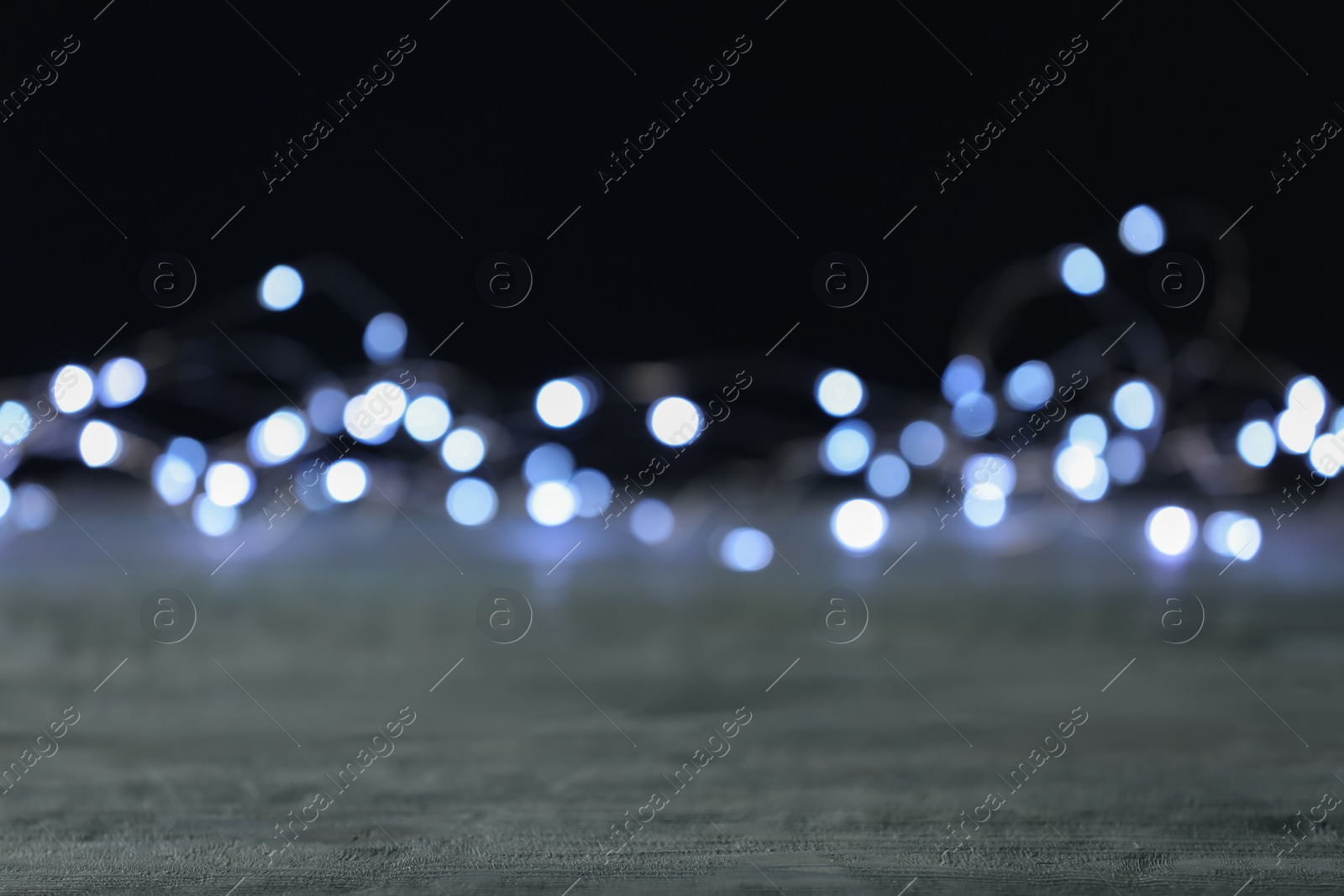 Photo of Beautiful lights on grey table, blurred view
