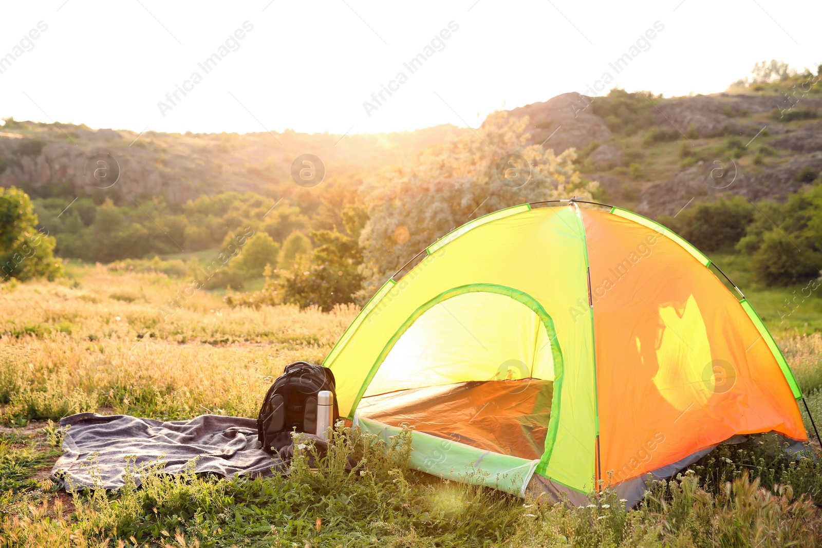 Photo of Camping gear and tourist tent in wilderness on sunny day