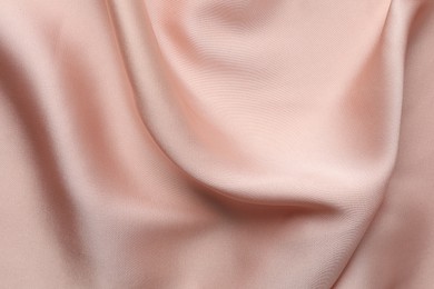 Photo of Crumpled pink silk fabric as background, top view