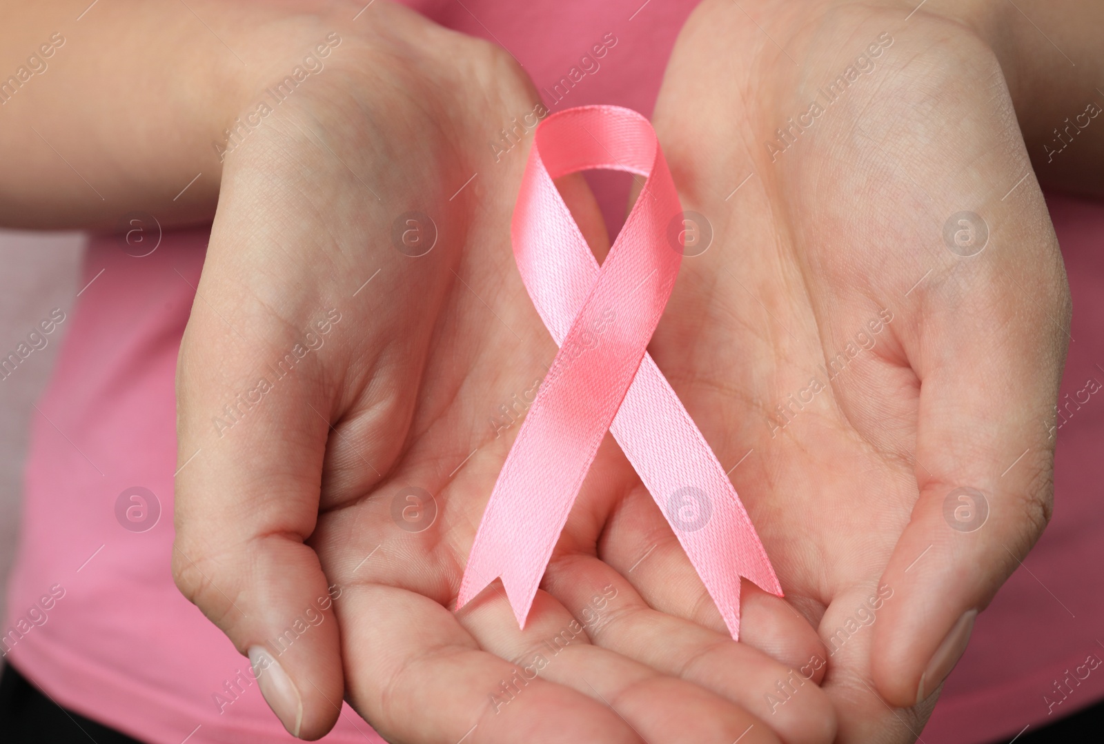 Photo of Woman holding pink ribbon, closeup. Breast cancer awareness