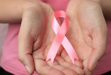 Photo of Woman holding pink ribbon, closeup. Breast cancer awareness