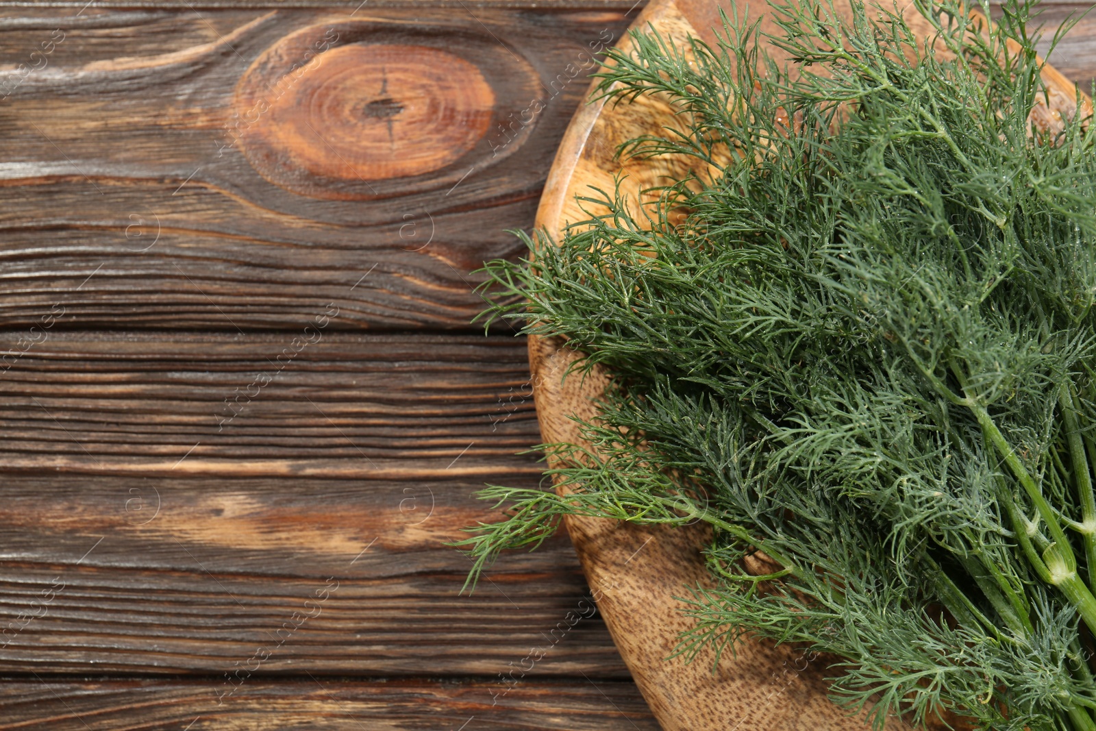 Photo of Bunch of fresh green dill on wooden table, top view. Space for text