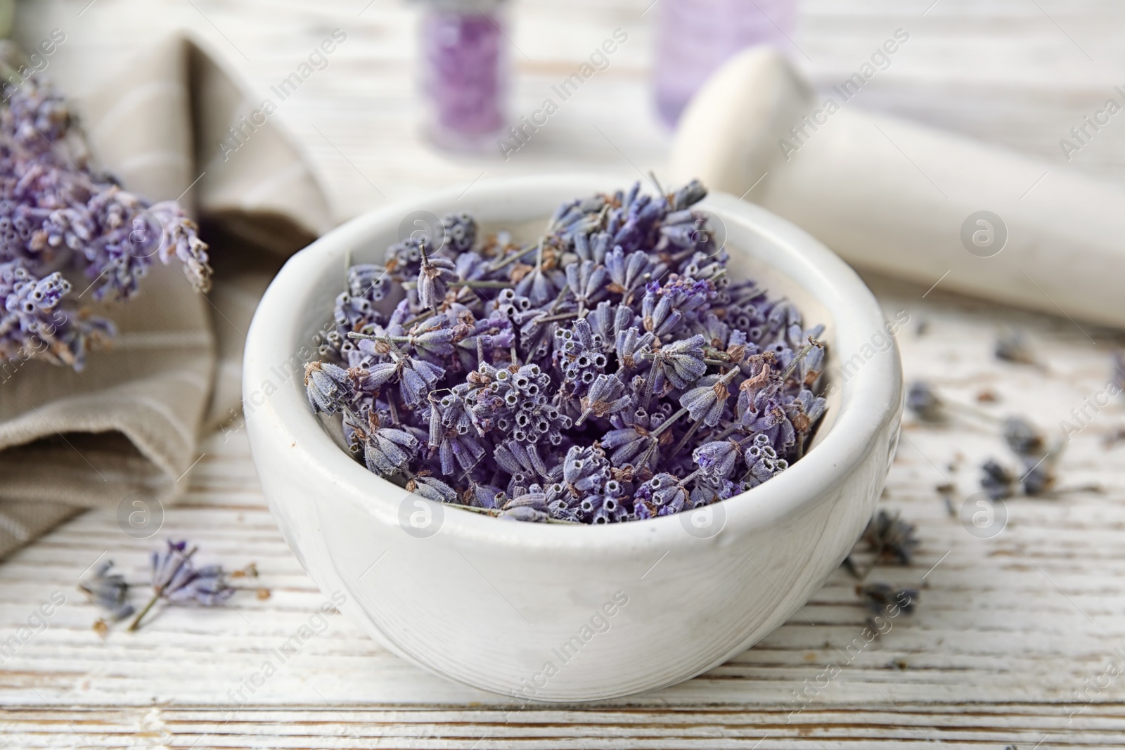 Photo of Mortar with lavender flowers on table. Ingredient for natural cosmetic