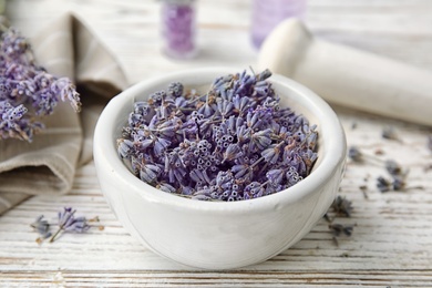 Photo of Mortar with lavender flowers on table. Ingredient for natural cosmetic