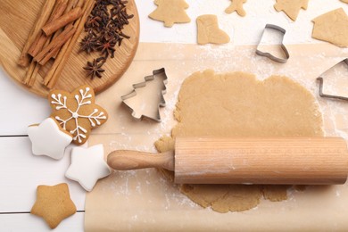 Photo of Making Christmas cookies. Flat lay composition with ingredients and raw dough on white wooden table