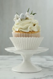 Tasty Easter cupcake with vanilla cream on white marble table