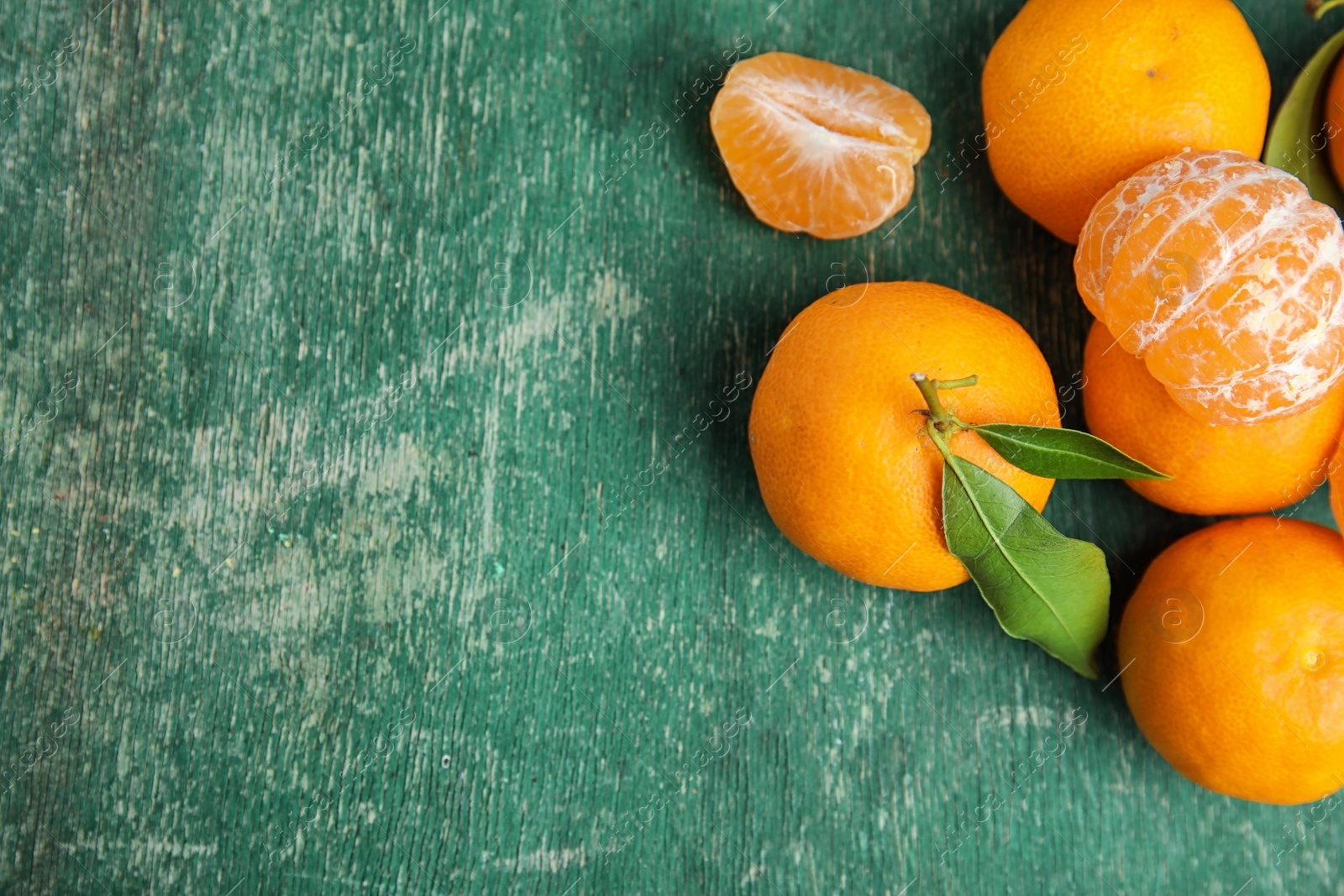 Photo of Fresh ripe tangerines and space for text on wooden background